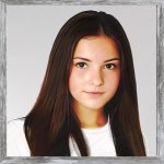 A watercolour painting of an attractive young girl aged 16. She has beautiful long straight deep brown hair and her eyes are chestnut coloured. Her face has a gentle expression with a hint of a smile. She is wearing a plain white T shirt (and blue jeans out of shot).