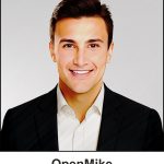 A watercolour painting of the school teacher Michael Rafone. In his late twenties, he has a pleasant smile and looks like a decent bloke, well groomed, dark brown hair and deep chestnut eyes. He's wearing a black suit jacket and a white shirt, but no tie. In his late twenties, he has a pleasant smile and looks like a decent bloke. The image is labelled OpenMike which is the name he uses every week at the Noble Coliseum when he hosts Saturday Night Fun Night.