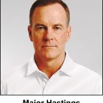 A watercolour painting of a stern man in his mid forties. His military style short brown hair shows traces of grey at the sides. His light hazel eyes and neutral smile indicate a purposeful temperament. He is wearing cricket whites. The image is labelled Major Hastings. He is a fictitious officer in the Lancaster Garrison, and is the fictitious president of Lancaster Cricket Club.